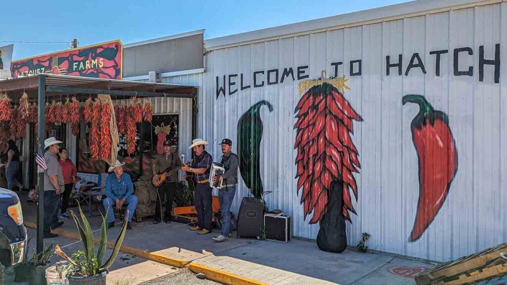 A welcome to Hatch sign at the Hatch Chile Festival, along with mariachis playing music