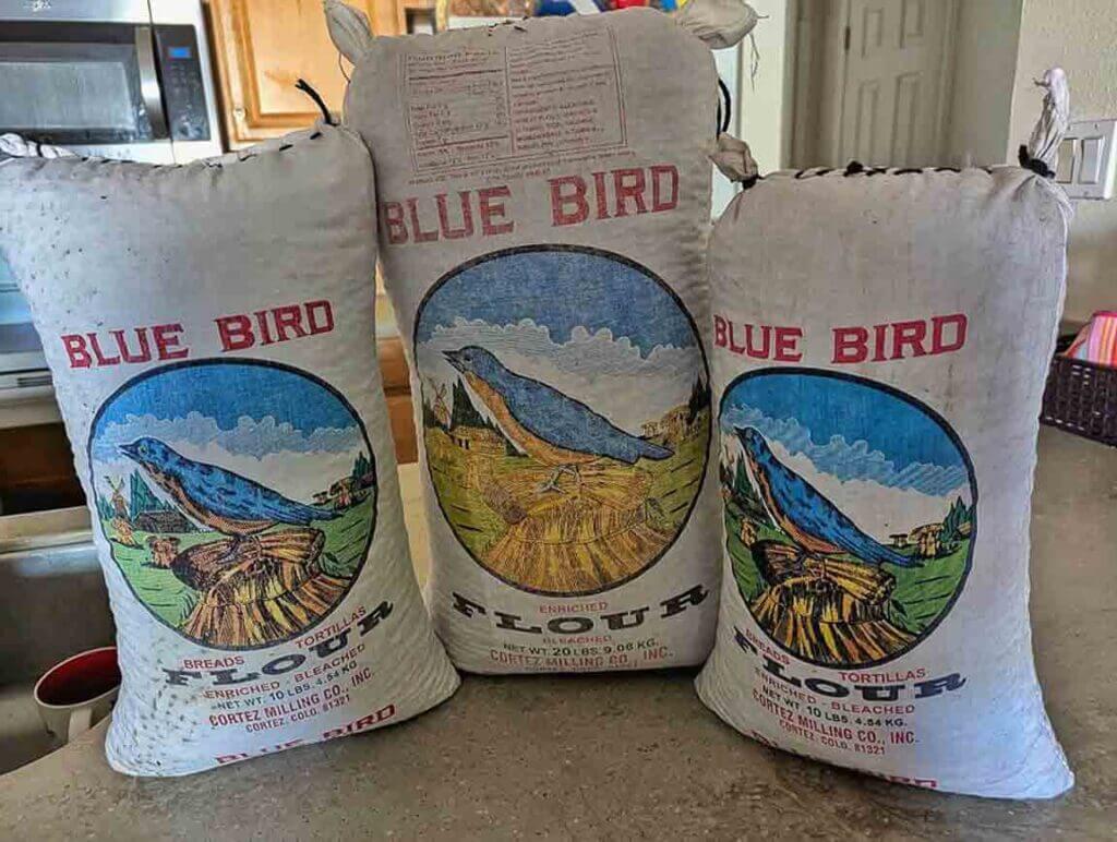 large blue bird flour bags filled with New Mexico piñon nuts